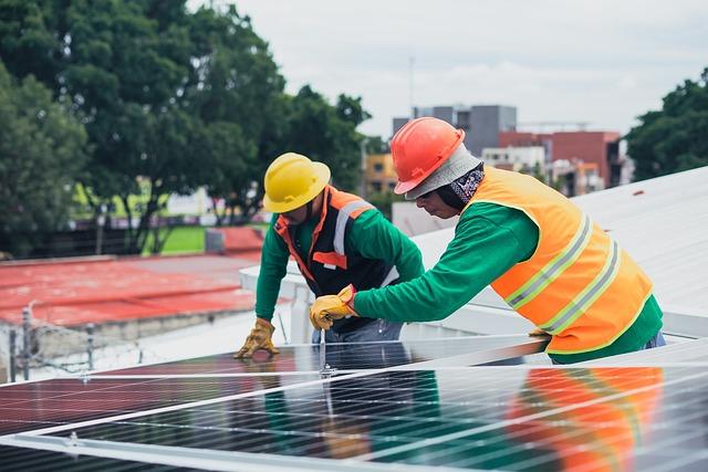 two workers installing a solar panel